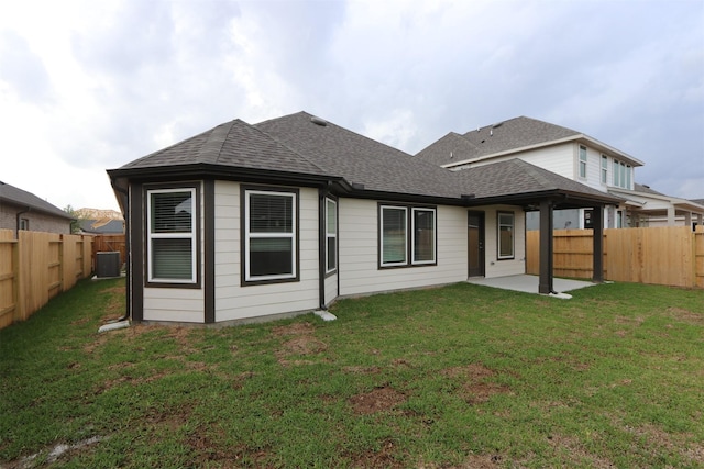 rear view of property featuring central air condition unit, a patio, a fenced backyard, and a shingled roof
