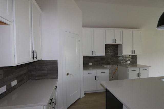 kitchen with white cabinets, light wood finished floors, and backsplash