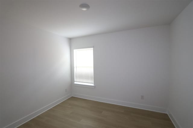 empty room with baseboards and wood finished floors
