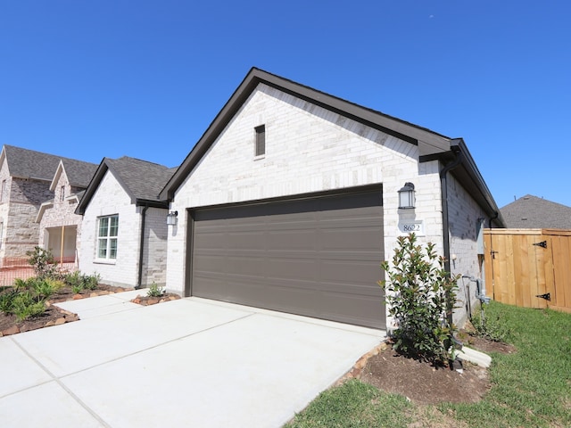 8622 Sun Coral Dr, Cypress, TX 77433 - view of front of house with an attached garage, brick siding, driveway, and fence