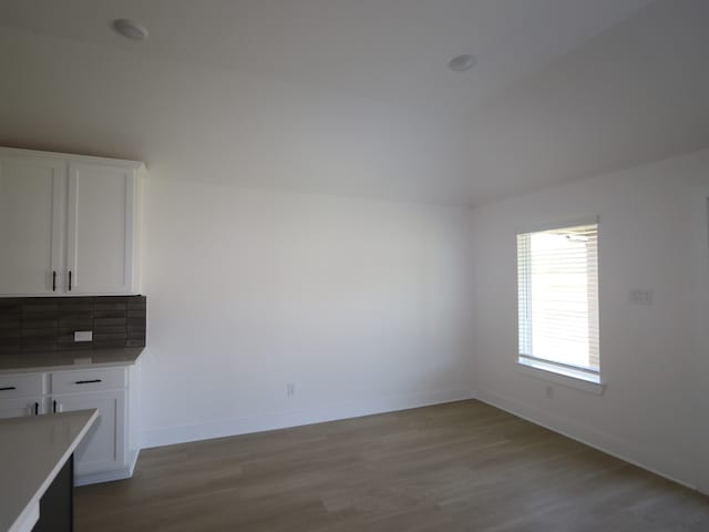 8622 Sun Coral Dr, Cypress, TX 77433 - unfurnished dining area featuring lofted ceiling, baseboards, and wood finished floors