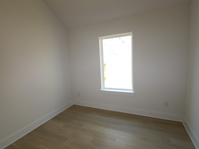 8622 Sun Coral Dr, Cypress, TX 77433 - empty room with baseboards, vaulted ceiling, and wood finished floors