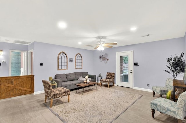 living room with ceiling fan and light wood-type flooring