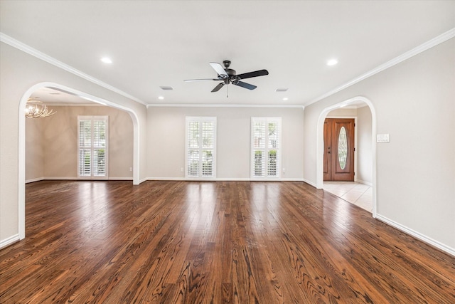 unfurnished living room with hardwood / wood-style floors, ceiling fan with notable chandelier, crown molding, and a healthy amount of sunlight