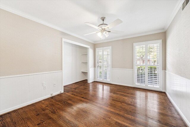 empty room with crown molding, ceiling fan, and dark wood-type flooring