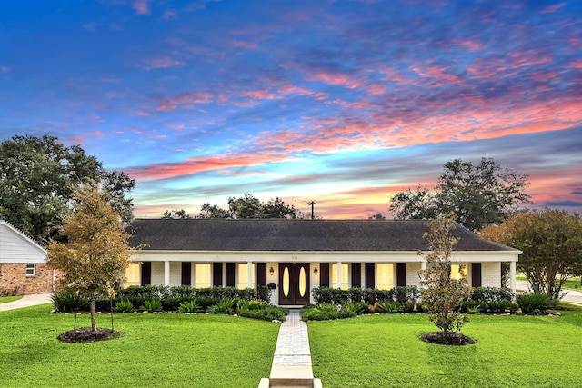 single story home featuring a yard and brick siding