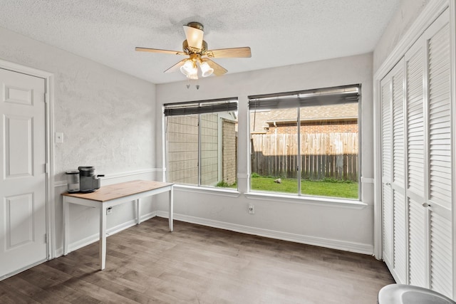 interior space featuring ceiling fan, hardwood / wood-style floors, and a textured ceiling