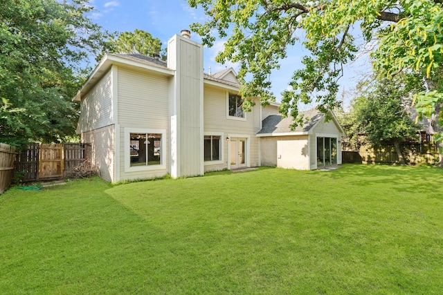 rear view of property featuring a lawn