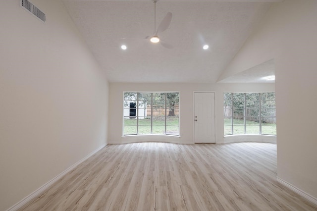 empty room featuring ceiling fan, a textured ceiling, high vaulted ceiling, and light hardwood / wood-style flooring