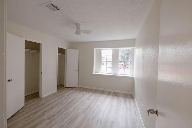 unfurnished bedroom featuring ceiling fan, light hardwood / wood-style floors, and a textured ceiling