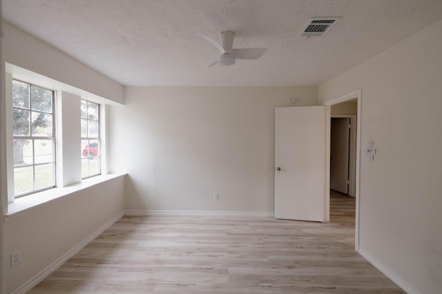 unfurnished room featuring ceiling fan, a textured ceiling, and light hardwood / wood-style flooring