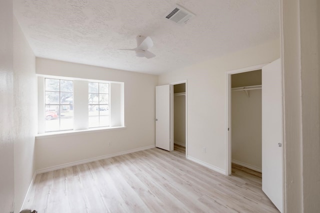 unfurnished bedroom featuring a textured ceiling, light hardwood / wood-style floors, and ceiling fan