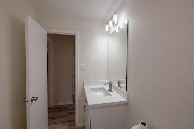 bathroom with vanity, a textured ceiling, and hardwood / wood-style flooring