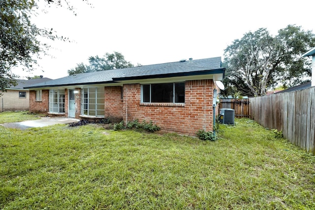 back of property featuring a lawn and cooling unit