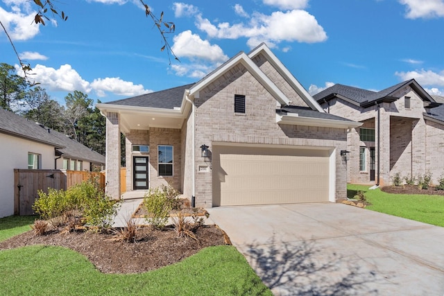 view of front facade with an attached garage, fence, concrete driveway, and brick siding