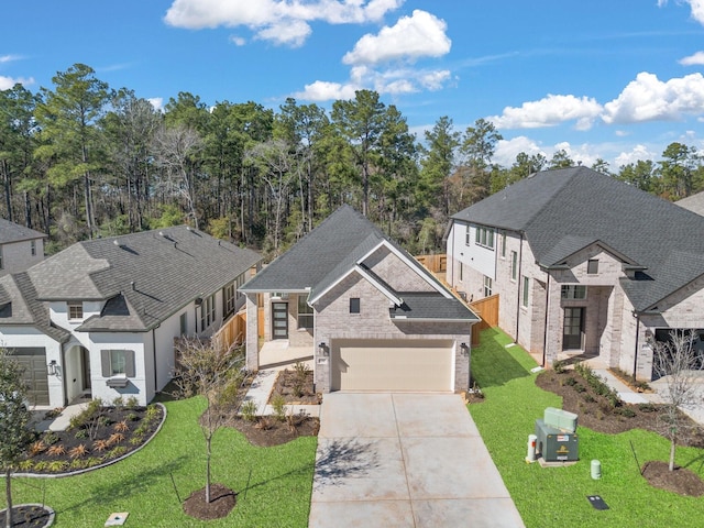 view of front of house featuring a garage, a shingled roof, concrete driveway, a front lawn, and brick siding