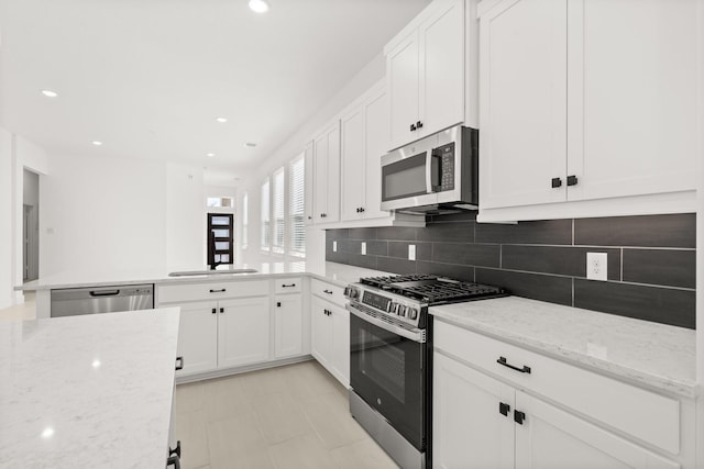 kitchen featuring white cabinets, stainless steel appliances, and backsplash