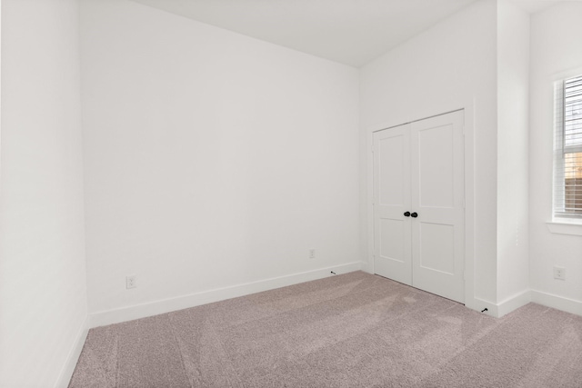 spare room featuring baseboards and carpet flooring