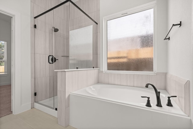 bathroom with a stall shower, a garden tub, and tile patterned floors