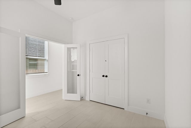 unfurnished bedroom with a ceiling fan, a closet, baseboards, and wood finished floors