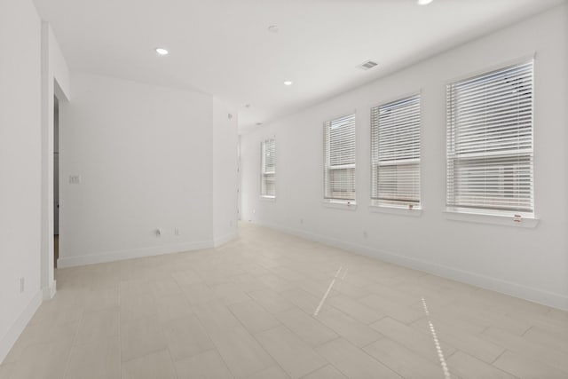 empty room with recessed lighting, visible vents, and baseboards