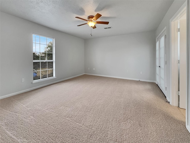 unfurnished bedroom featuring carpet flooring, a textured ceiling, and ceiling fan