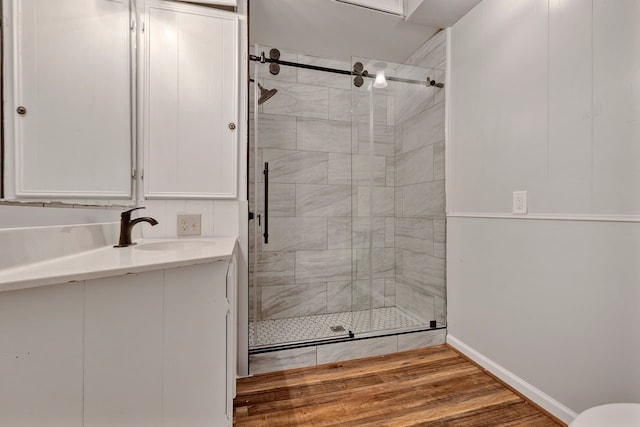 bathroom featuring hardwood / wood-style flooring, vanity, and an enclosed shower