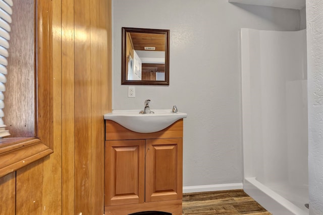 bathroom featuring vanity, a shower, and wood-type flooring