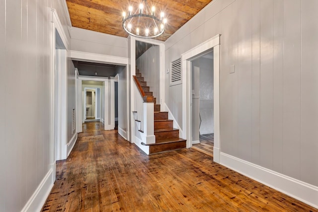 hallway featuring hardwood / wood-style flooring, a notable chandelier, wood walls, and wood ceiling