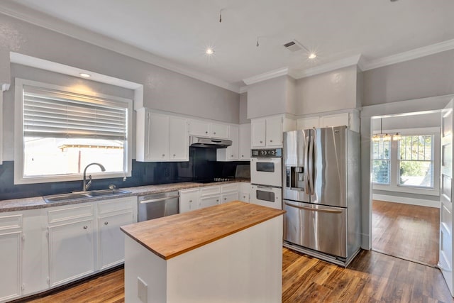 kitchen featuring a center island, sink, a healthy amount of sunlight, white cabinetry, and stainless steel appliances