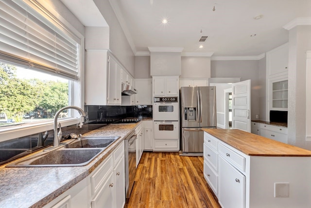 kitchen with white cabinets, light hardwood / wood-style floors, sink, and appliances with stainless steel finishes