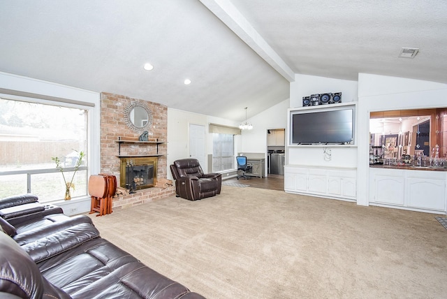 carpeted living room featuring a fireplace, lofted ceiling with beams, and a textured ceiling