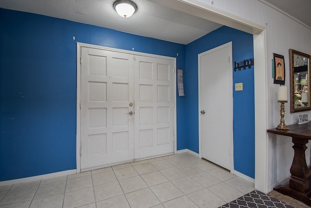 tiled entrance foyer featuring wood walls and a textured ceiling