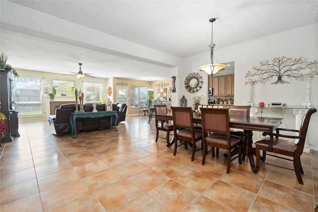 dining room with a ceiling fan, plenty of natural light, and light tile patterned floors