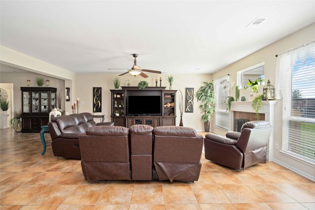 living room with ceiling fan, a fireplace, and light tile patterned flooring