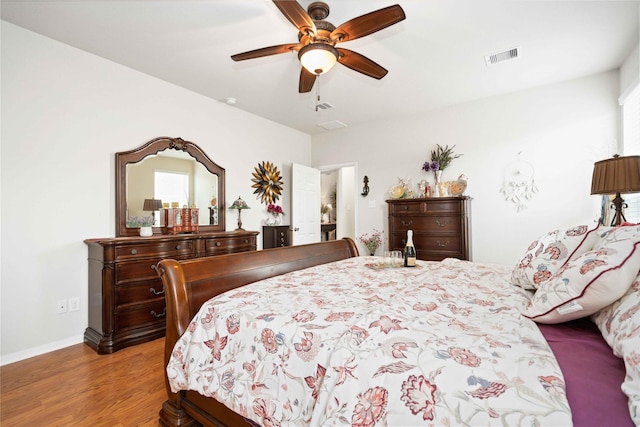 bedroom with light wood-type flooring, baseboards, visible vents, and ceiling fan