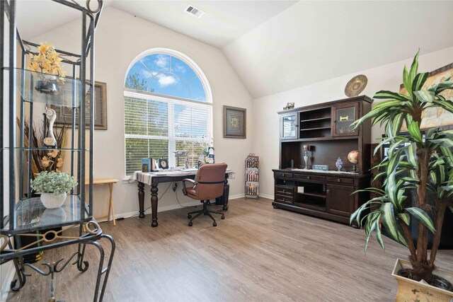 office space with vaulted ceiling and light hardwood / wood-style floors