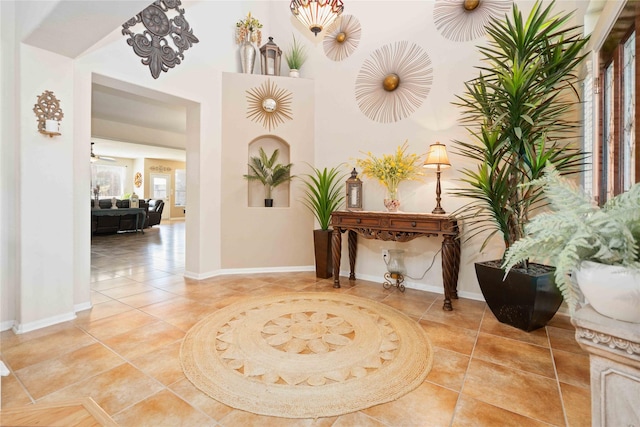 hallway with light tile patterned flooring and baseboards