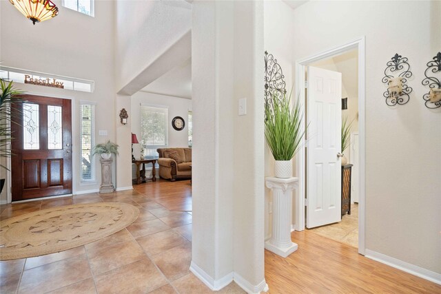 foyer entrance with light tile patterned flooring and a high ceiling