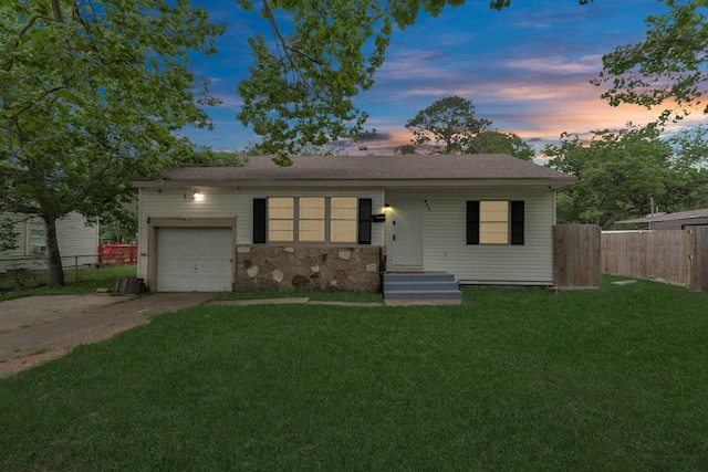 single story home featuring a lawn and a garage