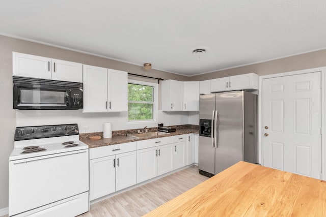 kitchen featuring white electric range oven, stainless steel fridge with ice dispenser, white cabinets, and sink