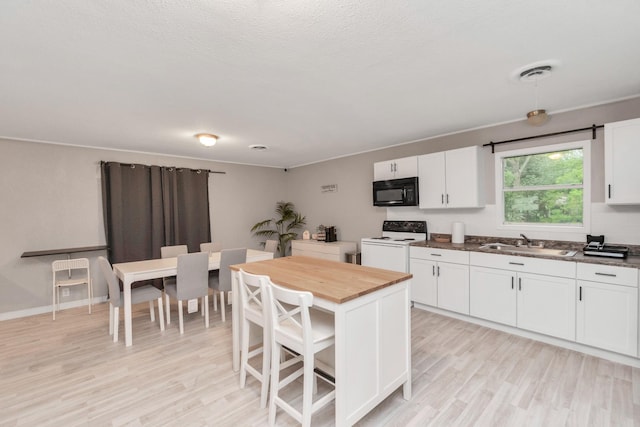 kitchen featuring white range with electric cooktop, white cabinets, sink, a kitchen island, and light hardwood / wood-style floors