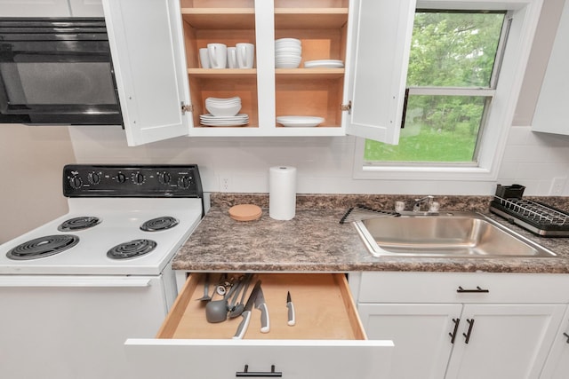 kitchen featuring decorative backsplash, white cabinetry, sink, and white electric range