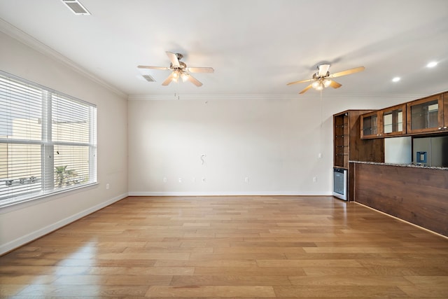 unfurnished room with ceiling fan, light hardwood / wood-style floors, and ornamental molding