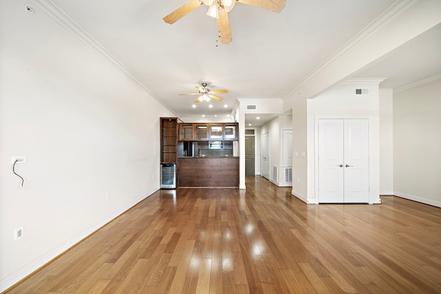 unfurnished living room with ceiling fan, light hardwood / wood-style floors, ornamental molding, and beverage cooler