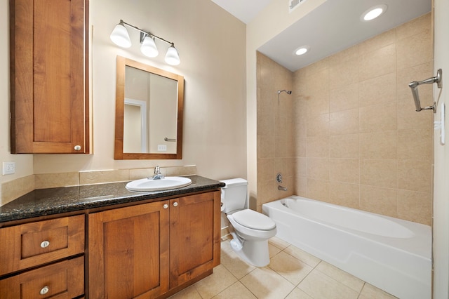 full bathroom with tile patterned flooring, vanity, tiled shower / bath combo, and toilet