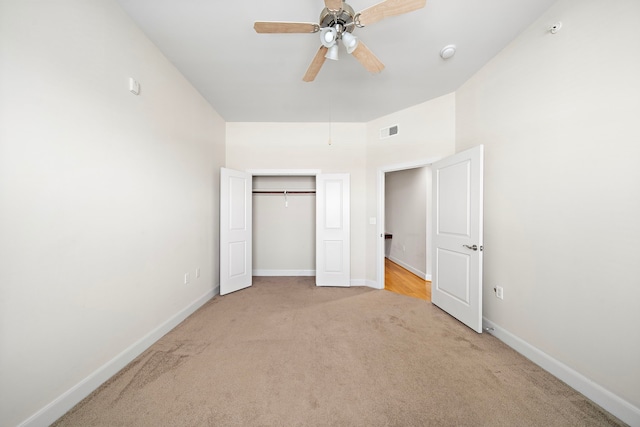 unfurnished bedroom with ceiling fan, light colored carpet, and a closet