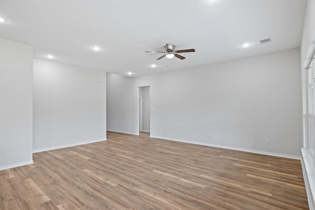 empty room with ceiling fan and light hardwood / wood-style flooring