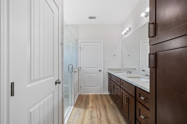 bathroom with vanity, wood-type flooring, and an enclosed shower