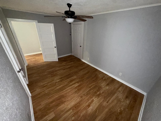 unfurnished bedroom featuring ceiling fan, dark hardwood / wood-style floors, and ornamental molding